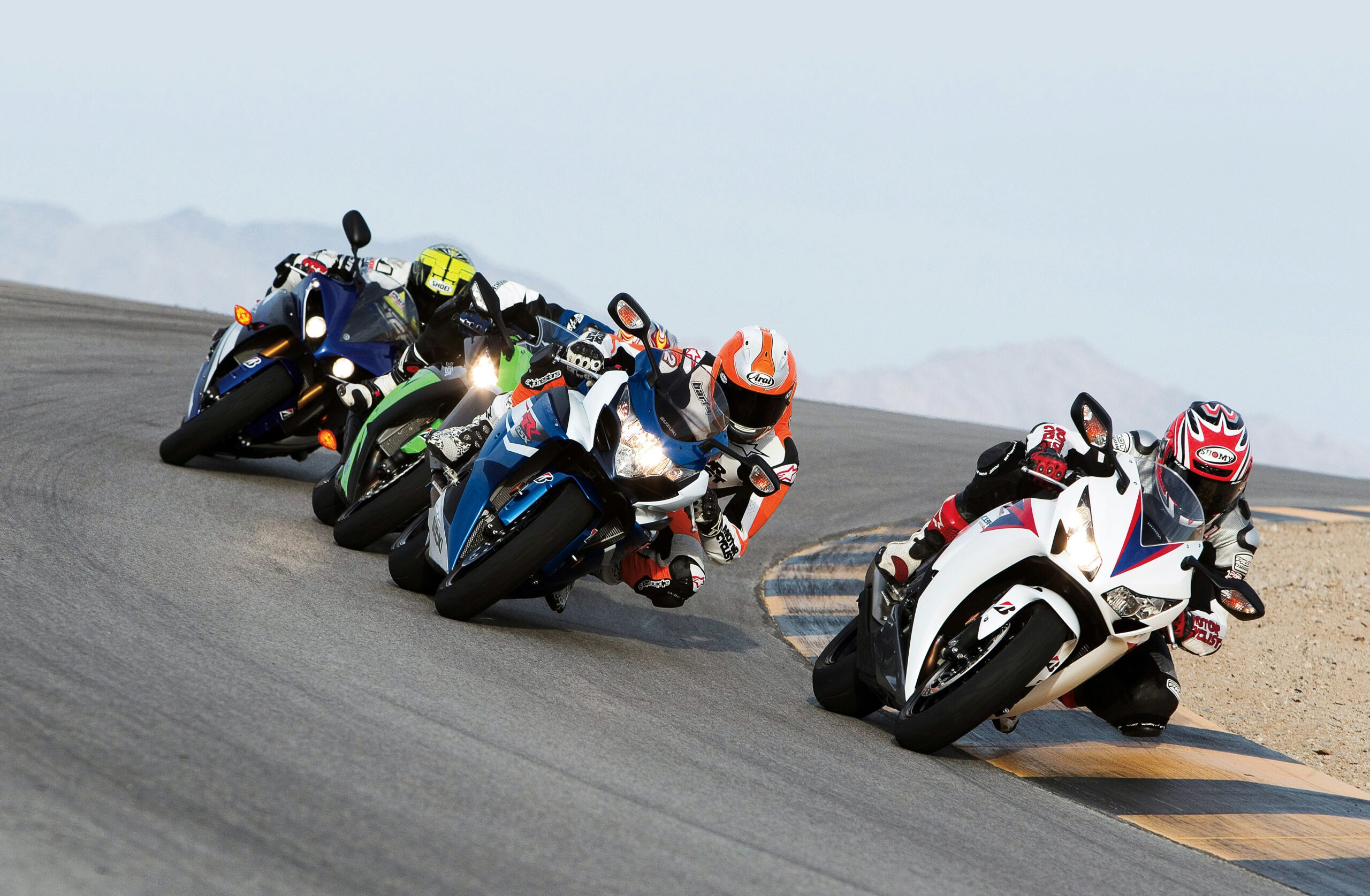 group of people riding sports motorcycles