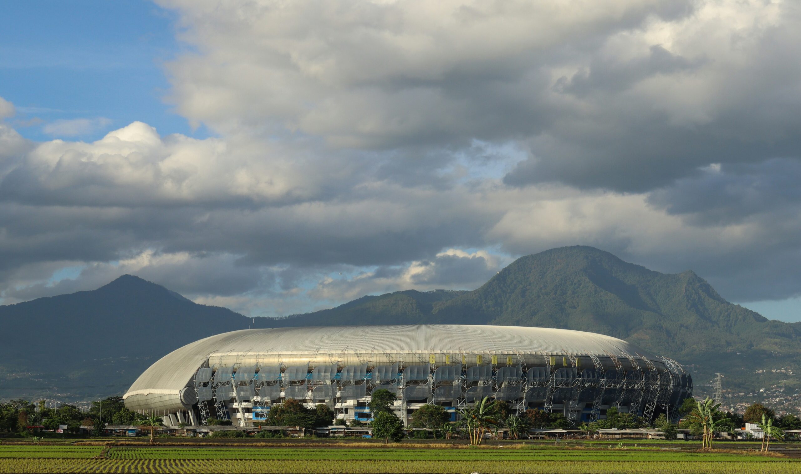 a large stadium with mountains in the background