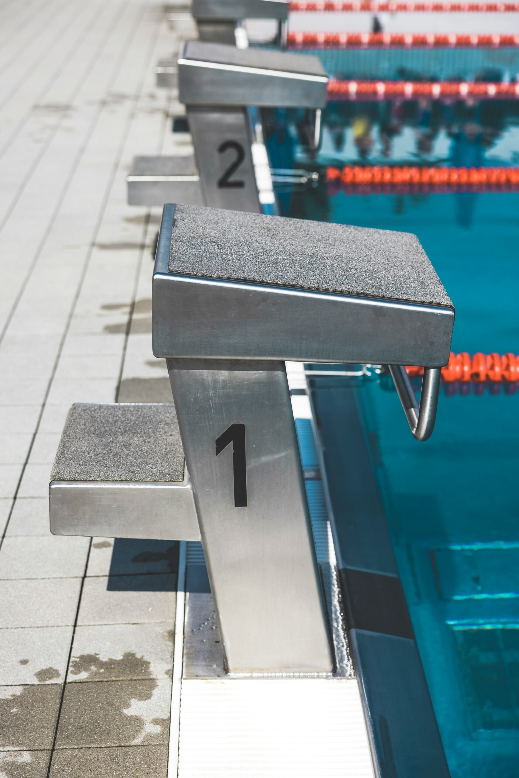 a row of benches sitting next to a swimming pool